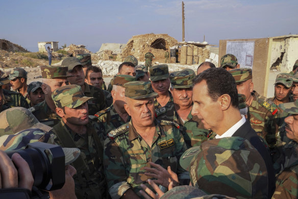 In a photo released on the official Facebook page of Syria's President, Bashar al-Assad speaks with troops in Idlib on Tuesday.