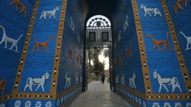 Orang-orang berjalan di dekat replika Ishtar Gate situs arkeologi Babel, Irak, pada hari Jumat.