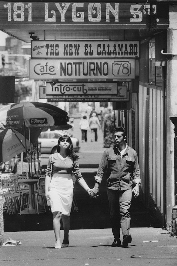 Young man and woman walking hand-in-hand along Lygon Street, Carlton in 1985.