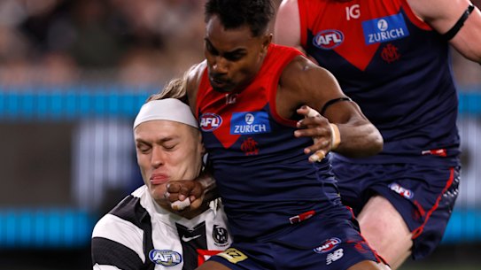Kysaiah Pickett of the Demons bumps Darcy Moore of the Magpies.