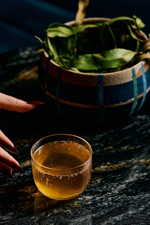 The Pyro-Flora cocktail featuring smoked vodka, burnt pear, lemon myrtle and strawberry gum soda, served in a bowl of smoked leaves.
