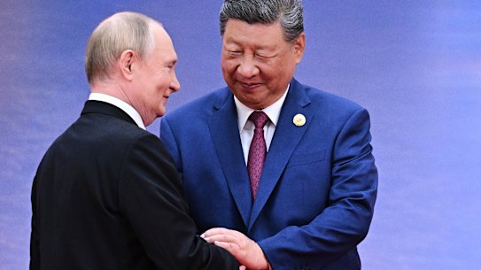 Vladimir Putin and Xi Jinping greet each other in Tianjin on Sunday.