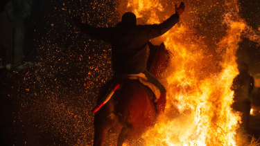 Men ride horses through bonfires during the annual “Las Luminarias” in San Bartolome de Pinares, Spain, on Sunday. 