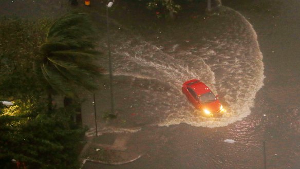 A vehicle negotiates a flooded street in Manila before dawn on Saturday.
