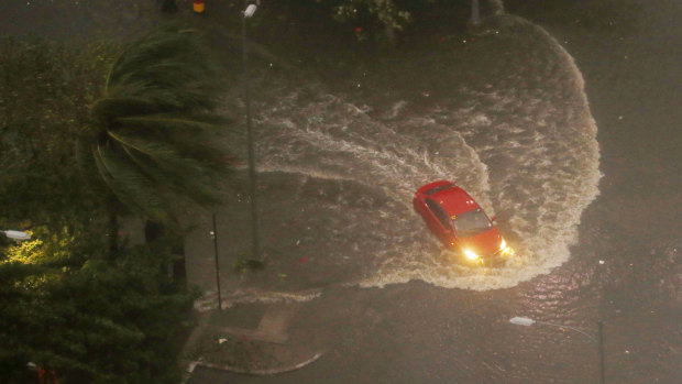 A vehicle negotiates a flooded street in Manila before dawn on Saturday.