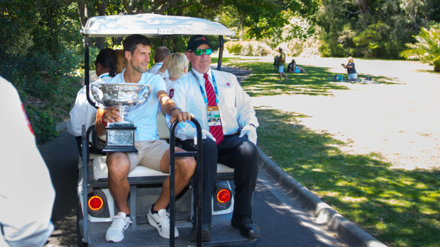 Djokovic rides through the gardens with his trophy.