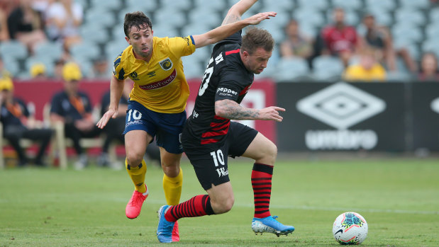 Mariners' Tommy Oar goes through the back of Wanderers debutant Simon Cox.