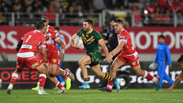 James Tedesco tries to evade Tongan defenders at Eden Park on Saturday night.