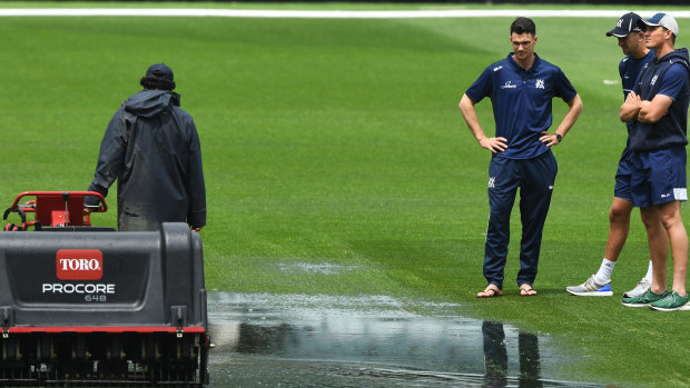 Victorians inspect the MCG after heavy rain delayed play.