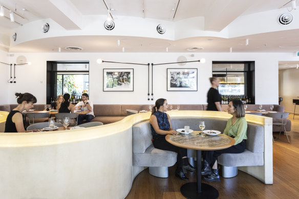 The dining room features curved, champagne-coloured booths.