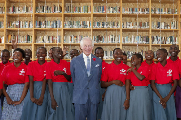 King Charles with students during his visit to the Eastlands Library to learn about a project that restores old libraries and encourages reading among children in the Makadara district of Nairobi.