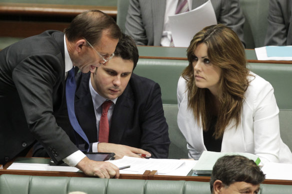 Then opposition leader Tony Abbott talks with Peta Credlin and Andrew Hirst during question time in 2012. 
