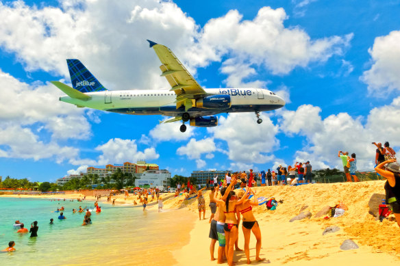  Planes landing at the Princess Juliana Airport fly over beachgoers. 