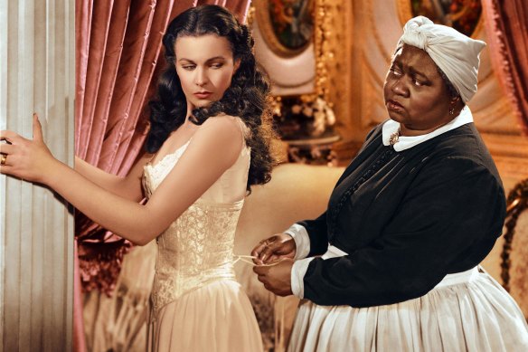 Hattie McDaniel as Mammy straps in Vivien Leigh in Gone with the Wind.