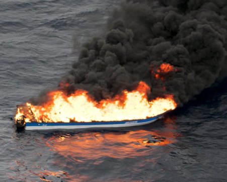 The panicked crew allegedly set fire to a boat stuffed with cocaine when a plane flew overhead.