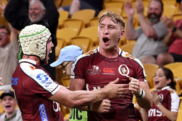 Tate McDermott celebrates a Reds try on Saturday at Suncorp Stadium.