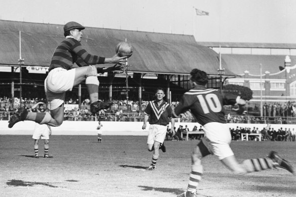 Yugoslavia's brilliant goalkeeper Vladimir Beara seldom takes a ball with his feet on the ground. Here he goes up for a shot while Australians Gordon Nunn and Harry Robertson (No. 10) move in. September 10, 1949