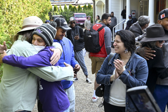 Carlos Munoz reaches out to hug a resident as the immigrants prepare to leave St. Andrews in Edgartown, Massachusetts after being shuttled there by Republican governors.