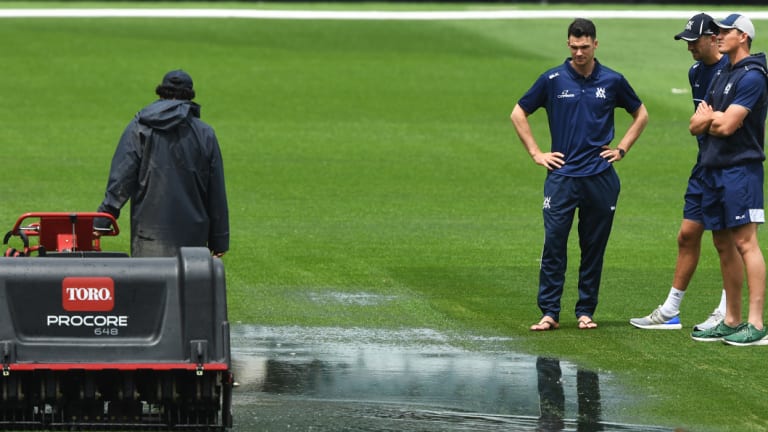 Victorians inspect the MCG after heavy rain delayed play.