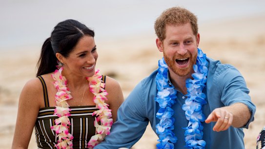 FILE - In this Friday, Oct. 19, 2018 file photo Britain’s Prince Harry and Meghan, Duchess of Sussex meet with a local surfing community group, known as OneWave, raising awareness for mental health and wellbeing in a fun and engaging way at Bondi Beach in Sydney, Australia. In a stunning declaration, Britain’s Prince Harry and his wife, Meghan, said they are planning “to step back” as senior members of the royal family and “work to become financially independent.” A statement issued by the couple Wednesday, Jan. 8, 2020 also said they intend to “balance” their time between the U.K. and North America. (Dominic Lipinski/Pool via AP)