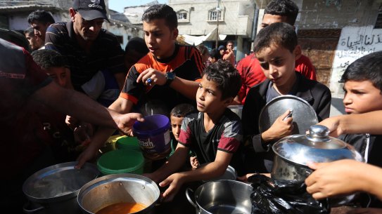 Palestinians queue to receive food at a makeshift charity kitchen in the southern Gaza Strip city of Rafah on Saturday.