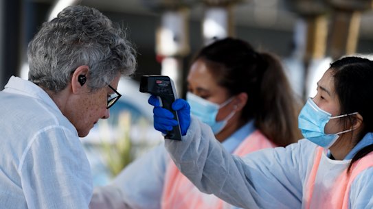 A woman has her temperature checked at the Sydney fish market as the nation deals with the COVID-19 crisis. 