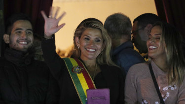 Bolivia's second Senate vice-president and opposition politician Jeanine Anez, centre, wearing the presidential sash, addresses the crowd from the balcony of the Quemado Palace in La Paz after declaring herself interim president.