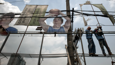 Workers install a street lamp in Manila. Corruption has meant the Philippines has failed to improve services and living standards even in times of economic growth.