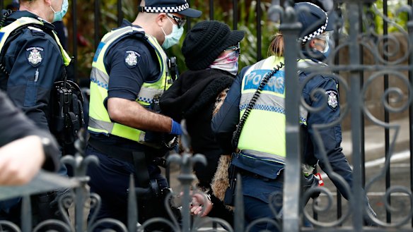 A woman is detained by Victoria Police on August 09, 2020.