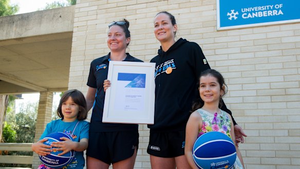 The Canberra Capitals players Kelsey Griffin and Keely Froling at the announcement the team and its supporters were the 2019 Canberra Citizen of the Year. Pictured with them are the team's No 1 ticket holder Daliah Lee, eight, (right) and her sister Heidi, six.