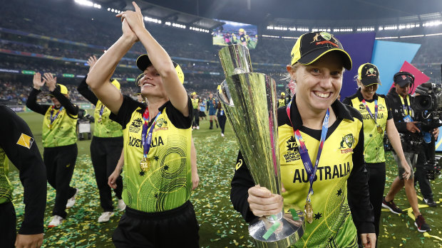 Alyssa Healy celebrates with the World Cup trophy.