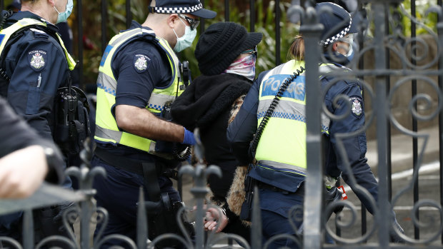 A woman is detained by Victoria Police on August 09, 2020.