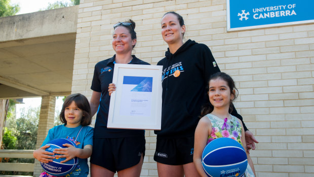 The Canberra Capitals players Kelsey Griffin and Keely Froling at the announcement the team and its supporters were the 2019 Canberra Citizen of the Year. Pictured with them are the team's No 1 ticket holder Daliah Lee, eight, (right) and her sister Heidi, six.