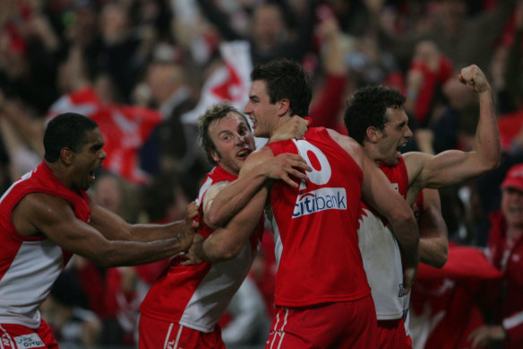 Swans players swarm Nick Davis after  he kicked the winning goal with seconds to go.
