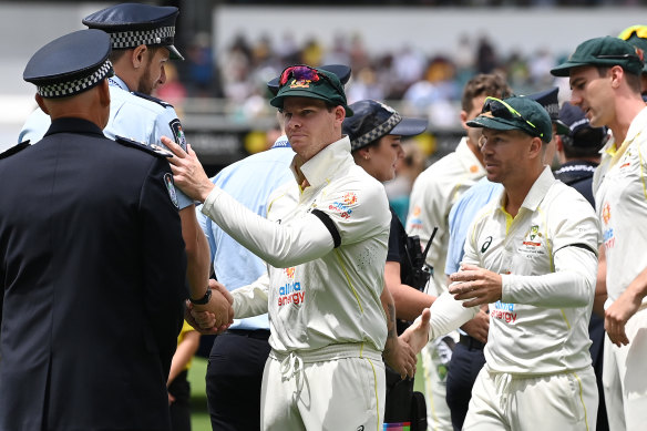 The Australian players offer their support to grieving police officers before the start of play on Saturday.
