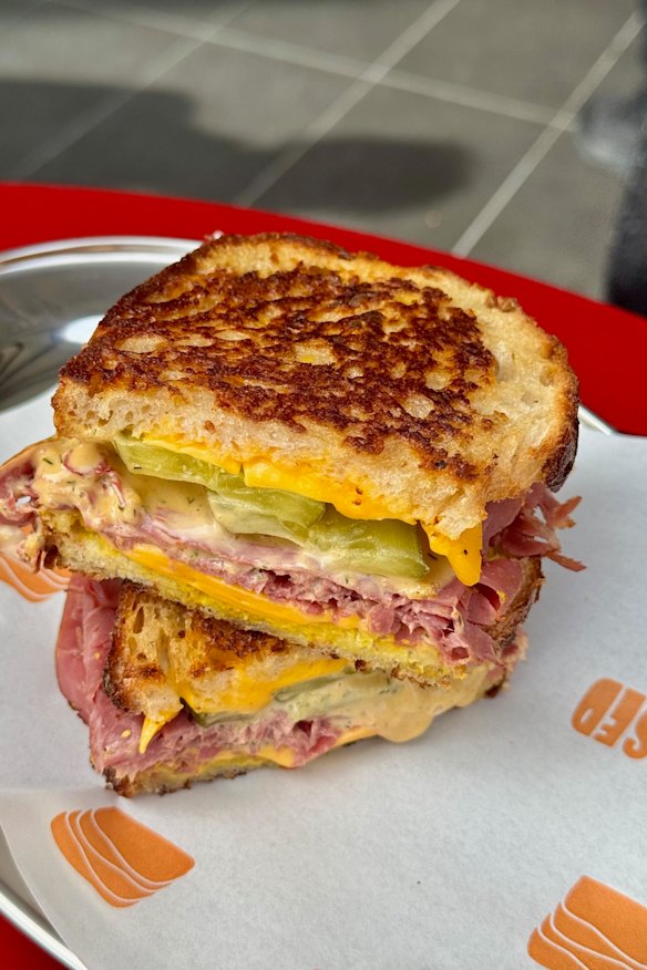 Smoked wagyu beef with pickles and melted cheese.