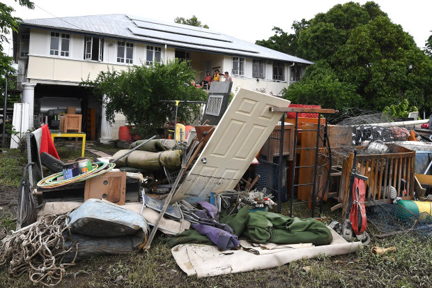 A large pile of water-damaged items in front of a flooded house in the Townsville suburb of Hermit Park on Wednesday.