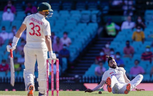Mohammed Siraj falls as he fields the ball hit by Australia's Marnus Labuschagne at the SCG.
