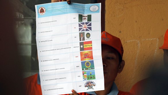 An electoral worker inspects a ballot at a polling station during the vote counting following the parliamentary election in Dili, East Timor, on Saturday.