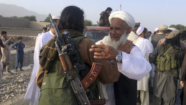 Taliban fighters gather with residents to celebrate a three-day cease fire marking the Islamic holiday of Eid al-Fitr, in Nangarhar province, east of Kabul, Afghanistan, in June.
