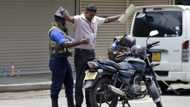 Navy soldiers perform security checks on motorists at a roadside in Colombo.