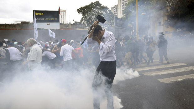 People were hit with tear gas during an opposition march in Caracas on Tuesday.