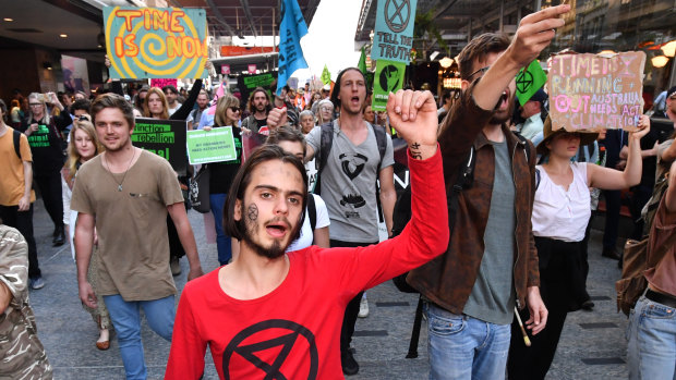 Eric Herbert (centre) with the Extinction Rebellion protesters as they march down the Queen Street Mall.