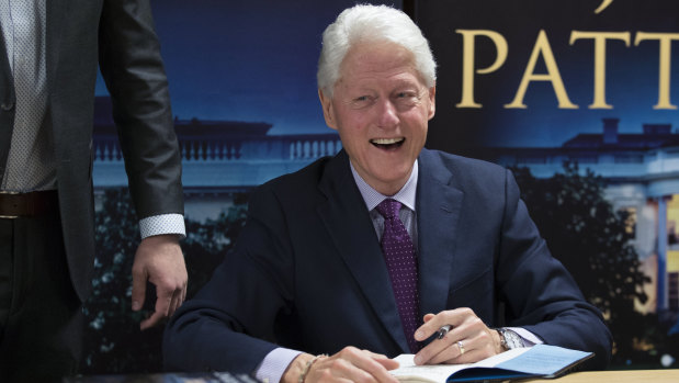 Former US president Bill Clinton smiles as he signs autographs during an event to promote his new novel with author James Patterson, The President is Missing.