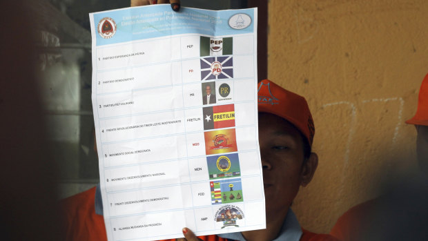 An electoral worker inspects a ballot at a polling station during the vote counting following the parliamentary election in Dili, East Timor, on Saturday.