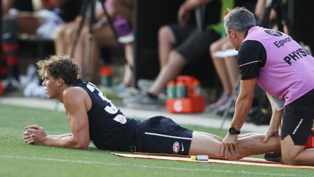Charlie Curnow is treated for cramp against Essendon.