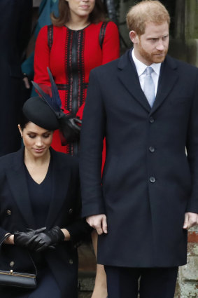 Prince Harry, stands with Meghan, Duchess of Sussex as she does a curtsy to the Queen after the Christmas day service.