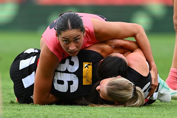 Dekota Baron of the Suns tackles Airlie Runnalls of the Magpies.