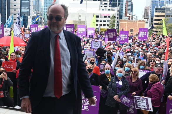Industrial Relations Minister Bill Johnston leaves a podium where he was addressing a crowd of public sector workers who at times chanted over his speech.