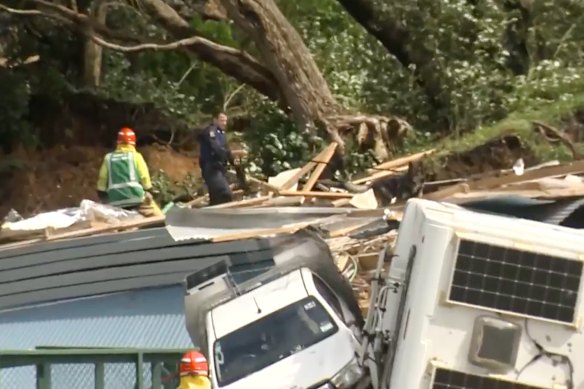 In questa immagine tratta da un video, un agente di polizia con un cane cerca persone vicino al luogo di una frana alla base del monte Maunganui, nell'Isola del Nord della Nuova Zelanda.